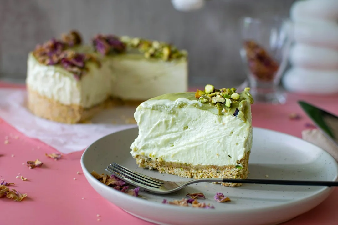 Decadent slice of baked pistachio cheesecake garnished with chopped nuts