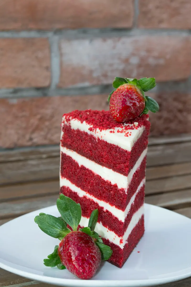 Freshly baked single serve red velvet cake topped with cream cheese frosting